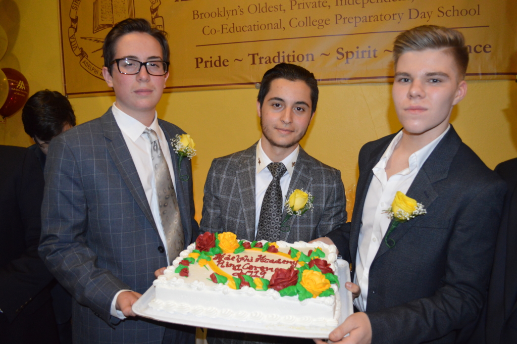 Class of 2020 members Andre, Ariel and Yevgen show off the evening's special cake!