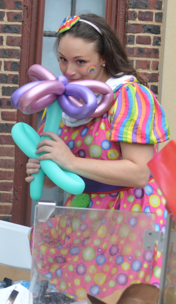 Rainbow T. Clown smells a freshly twisted balloon flower!
