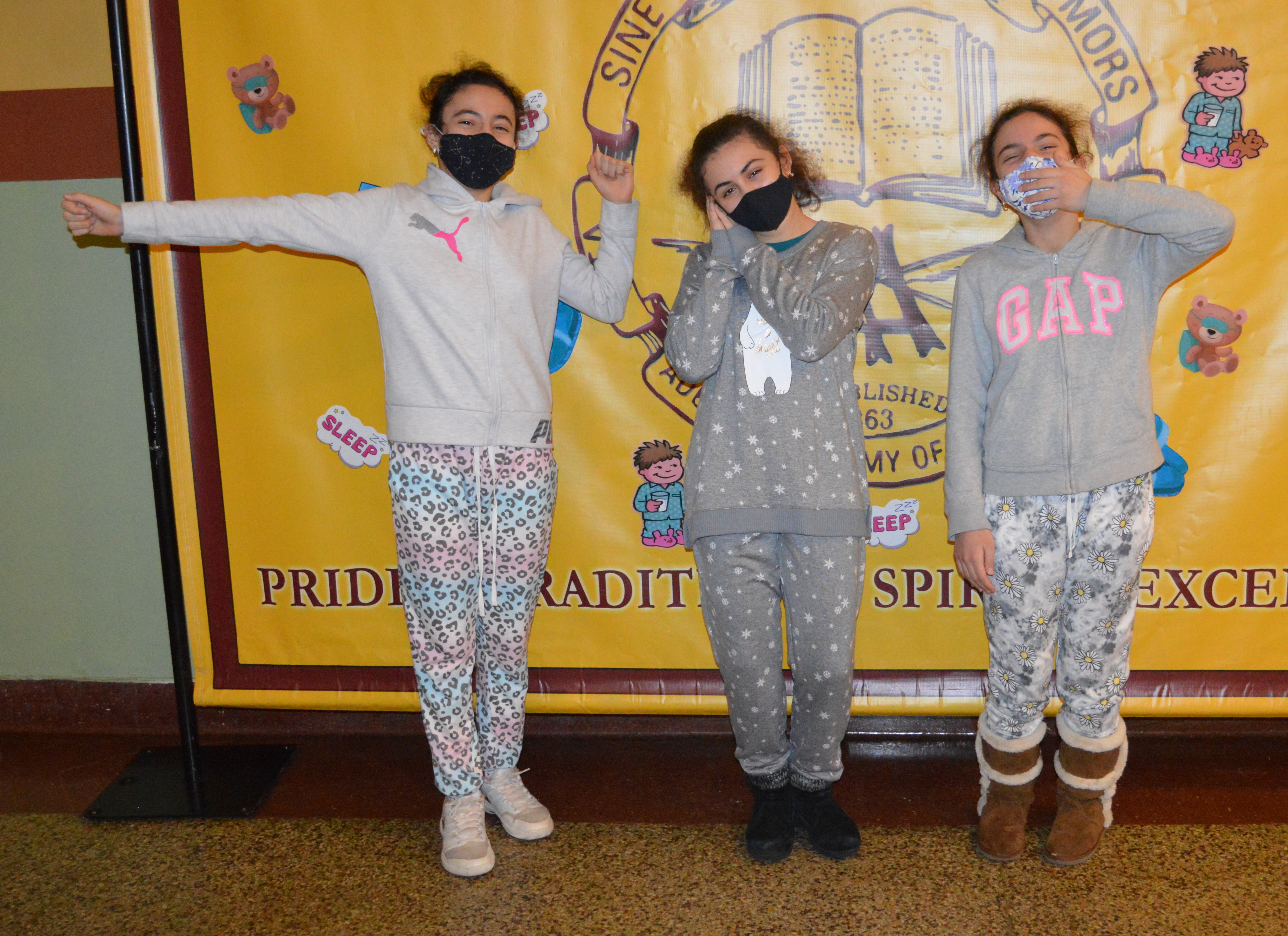 Middle Schoolers Sarah, Svetlana and Rebecca strike a pose in front of the Pajama Day banner!