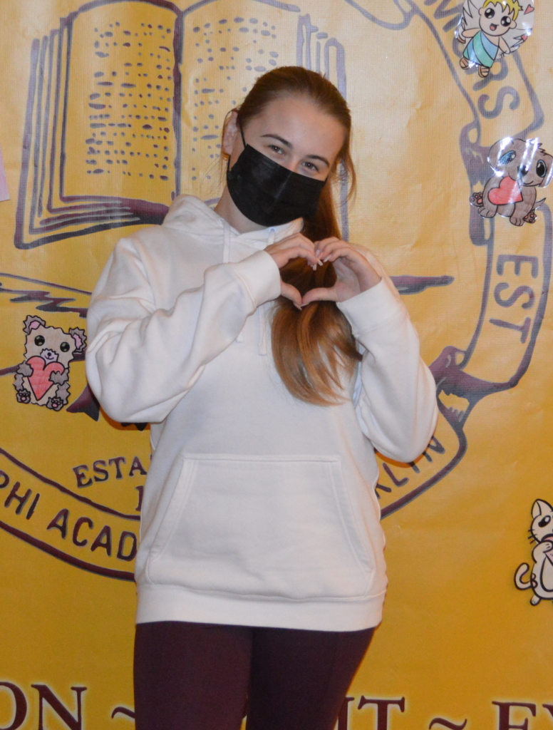 Upper Schooler Ilona strikes a loving pose in front of the backdrop!