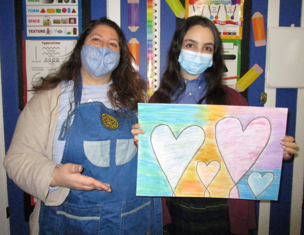 Art Instructor Ms. Fregara compliments Upper Schooler Maxelle on her pop art hearts!